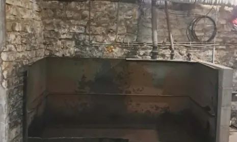 Cuve à fioul ouverte et vidée dans une cave en pierre, avant nettoyage